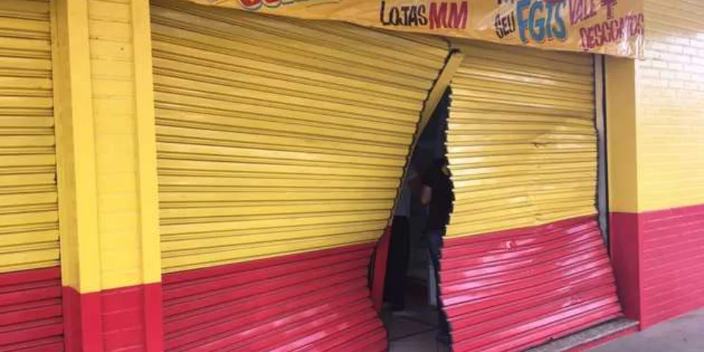 Porta da loja foi danificada durante a ação dos bandidos