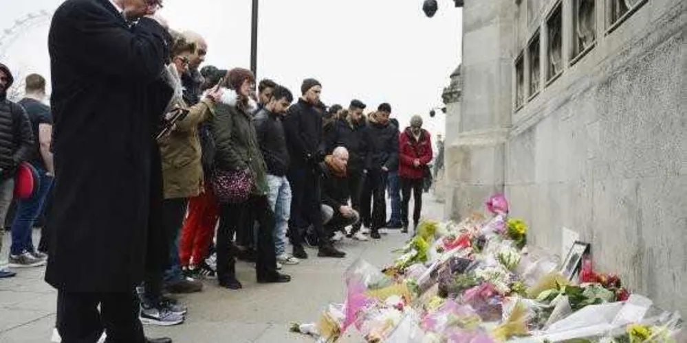 Pessoas observam homenagens às vítimas do atentado em Londres/ Foto: Hannah Mckay/ EPA/ Lusa