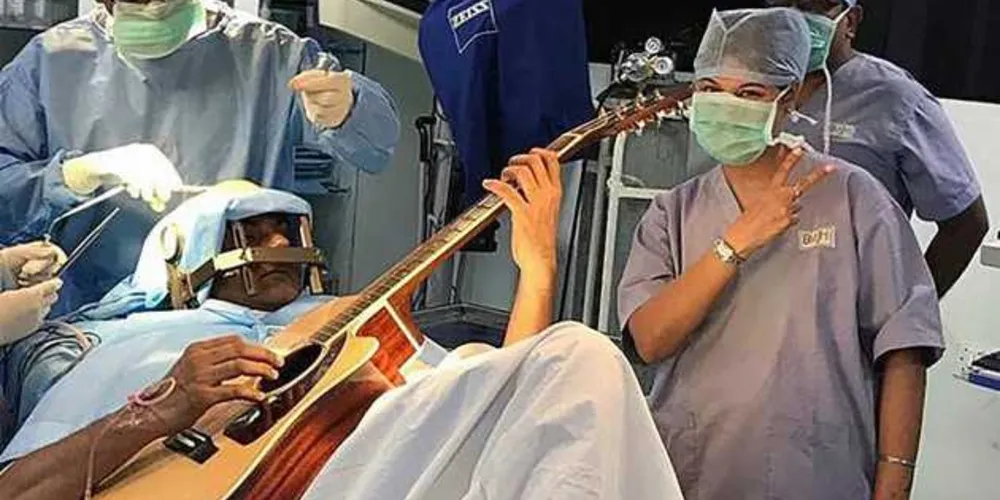 Abhishek Prasad, de 37 anos, toca violão durante uma cirurgia no cérebro, em Bangalore, no Hospital Mahveer Jain, na Índia/Foto: Reprodução Mahaveer Jain 