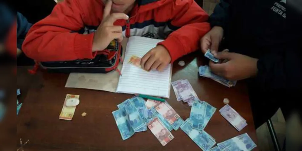 Alunos trabalhando com dinheiro fictício