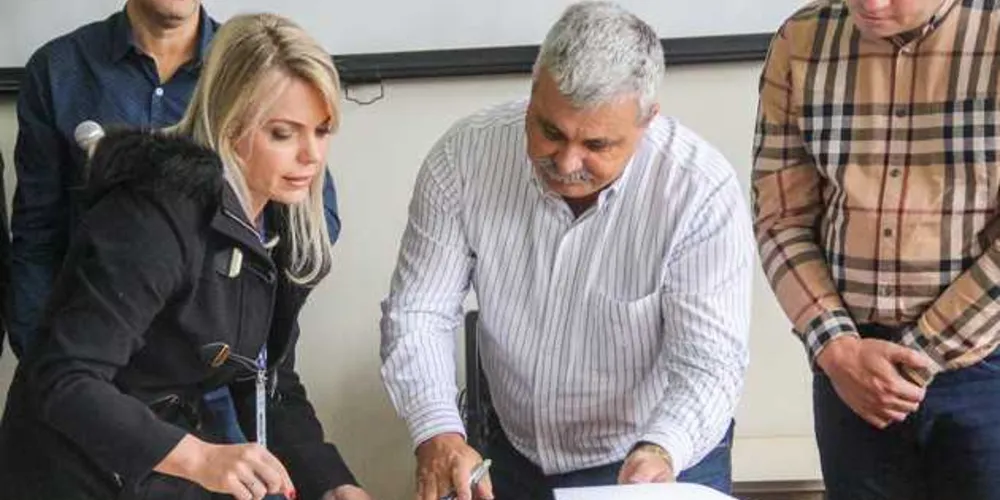 Prefeito Derbli, junto da gerente de Obras da Sanepar, Jeanne Schmdit, e do deputado Sandro Alex, assinando convênio