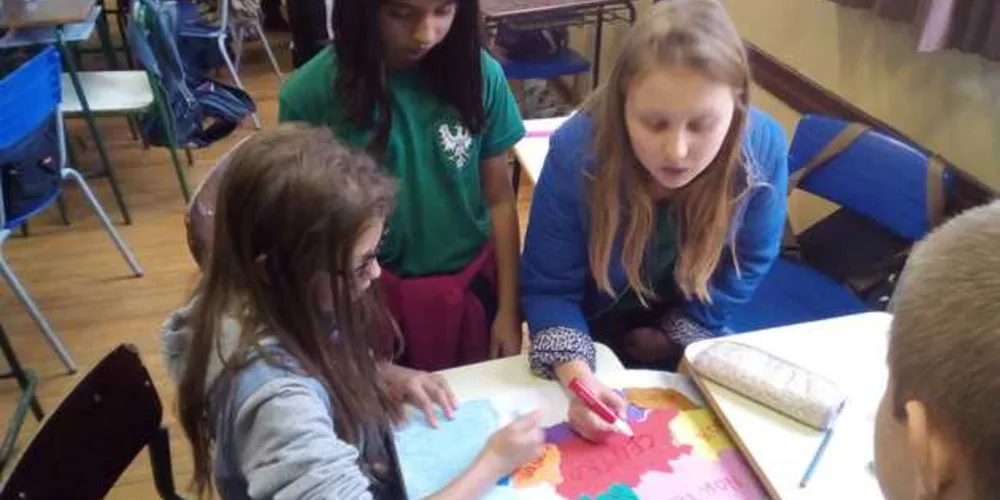 Grupo de alunos montando o mapa do Estado do Paraná com suas mesorregiões.