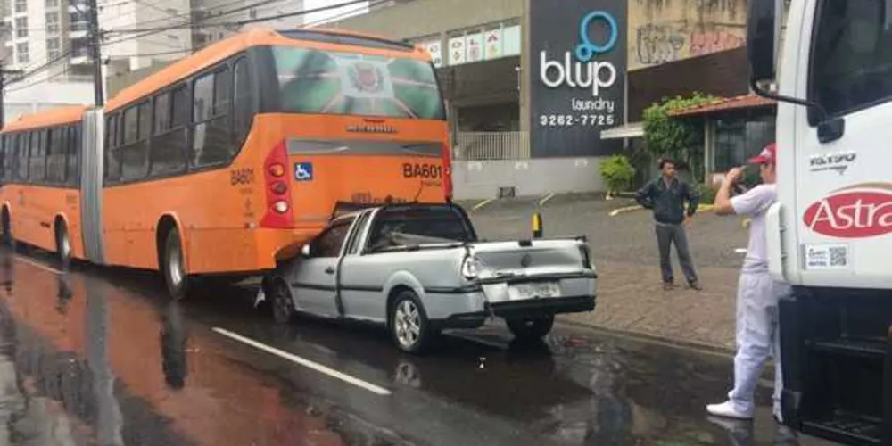 Imagem ilustrativa da imagem Carro é esmagado por caminhão e entra debaixo de ônibus