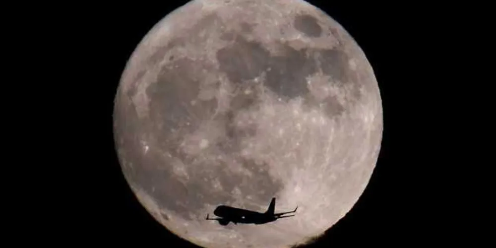 Avião de passageiros contra imagem da superlua na Inglaterra/Foto: Reuters 