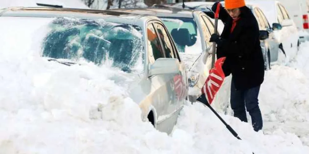 Mulher retira neve do seu carro em Boston/Foto: Divulgação Reuters