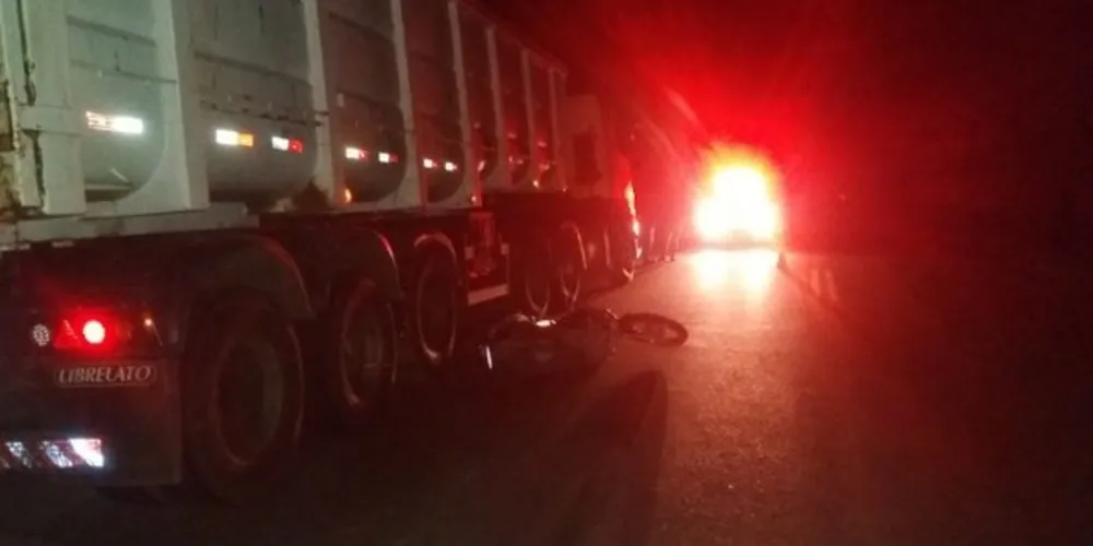 Moto foi parar embaixo do caminhão com o impacto