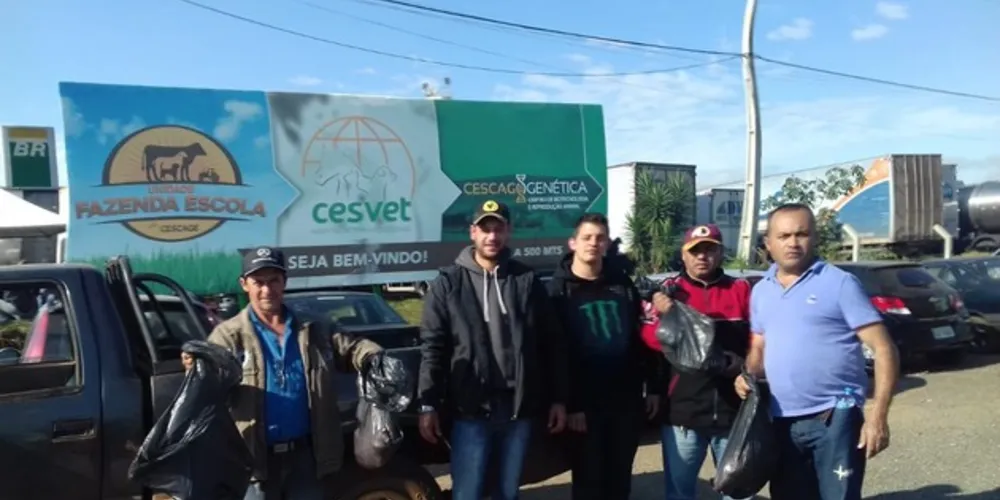 Um grupo de caminheiros estão parados em frente a Fazenda Escola da Instituição  