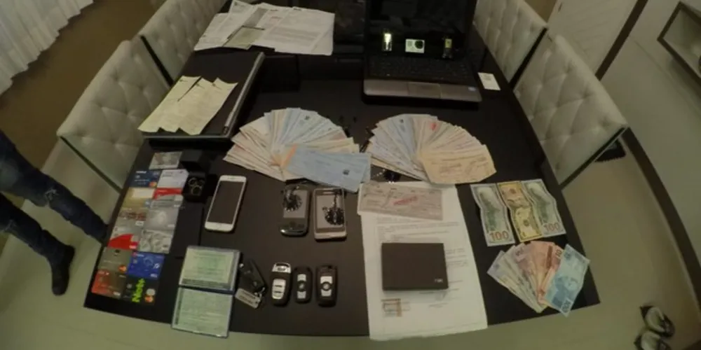 Com os detidos, a polícia apreendeu mais de R$ 100 mil em dinheiro, cheques, uma máquina que imprimi cartões e caça níqueis