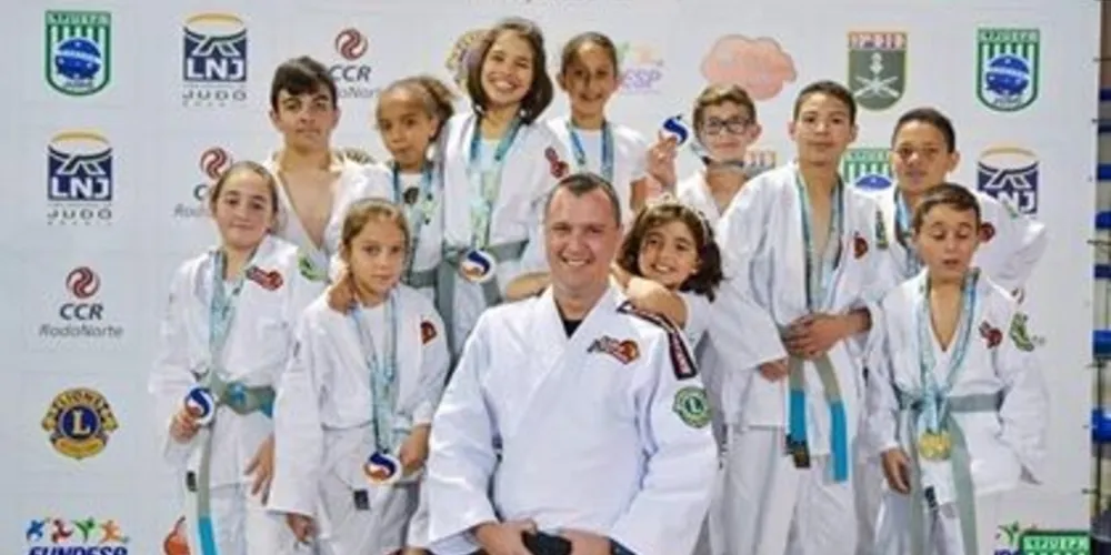 Professor Carlos Silva ao lado dos atletas da equipe 'Leões do Tatame'