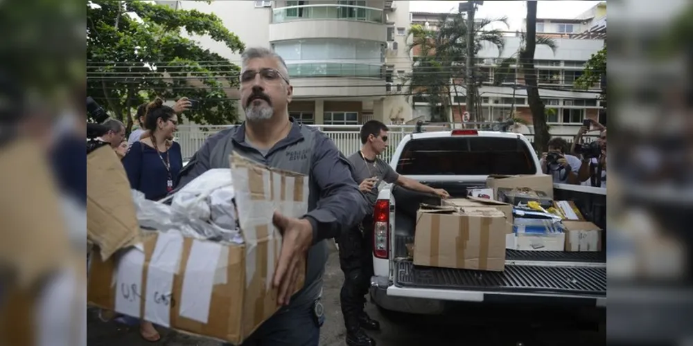 Policiais carregam caixas apreendidas em endereço ligado a suspeito de matar a vereadora Marielle Franco e o motorista Anderson Gomes 