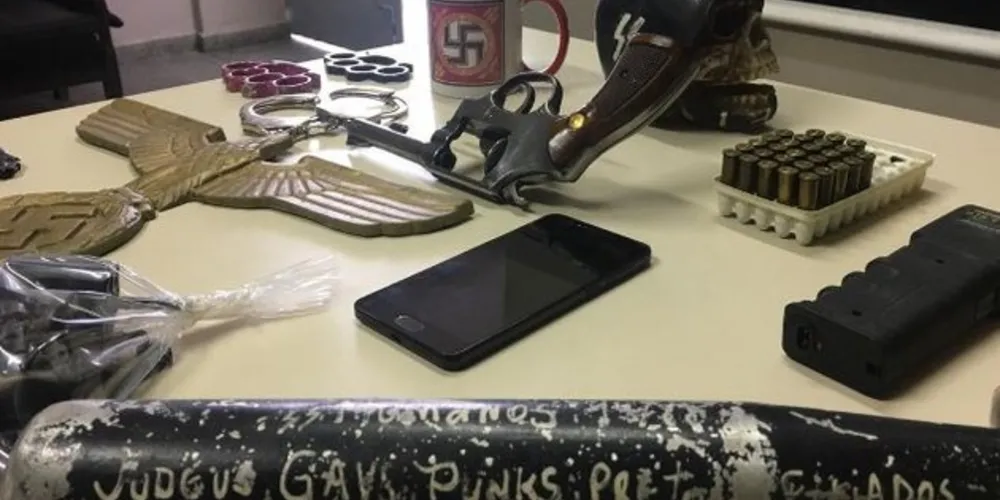 Acessório apreendido tem uma frase ofensiva e ameaçadora direcionada a ‘judeus, gays, punks, pretos e viciados’ 