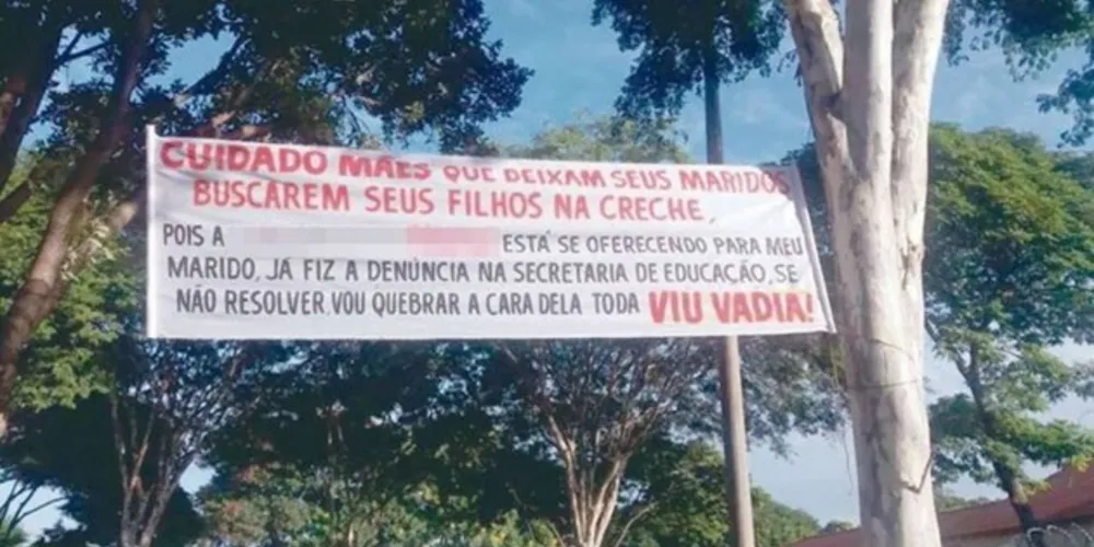 De acordo com a faixa, a mulher já fez denúncia na Secretaria de Educação e diz "Se não resolver, vou quebrar a cara dela toda"