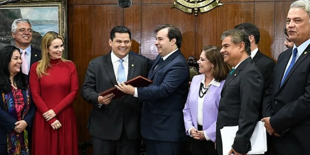 O presidente do Senado, Davi Alcolumbre, recebe de Rodrigo Maia o texto da proposta