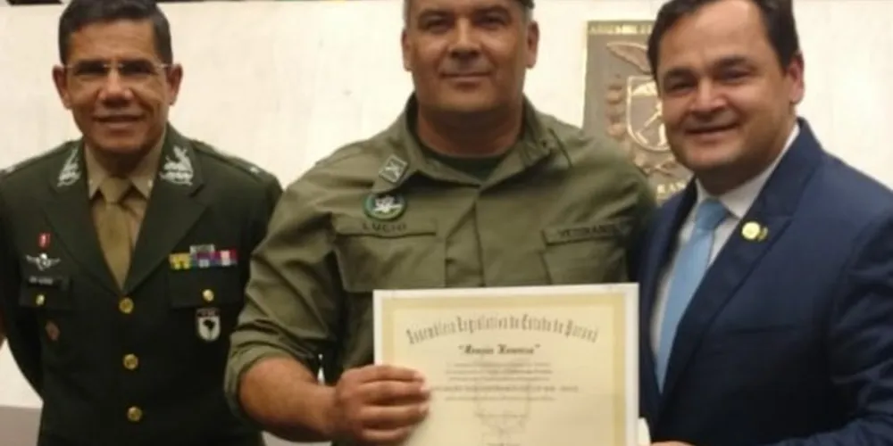 Lucio Barbosa, presidente da Associação, recebendo a homenagem das mãos do  deputado Subtenente Everton. Ao lado, o General de Brigada Aléssio Oliveira da Silva.