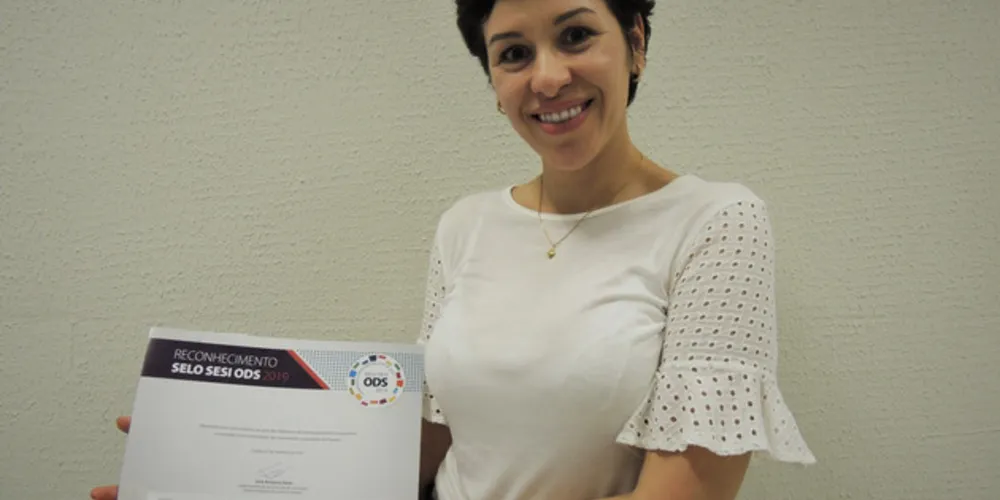 Coordenadora do curso de Direito da UniSecal, Renata Young Blood, com o certificado de reconhecimento do Sesi
