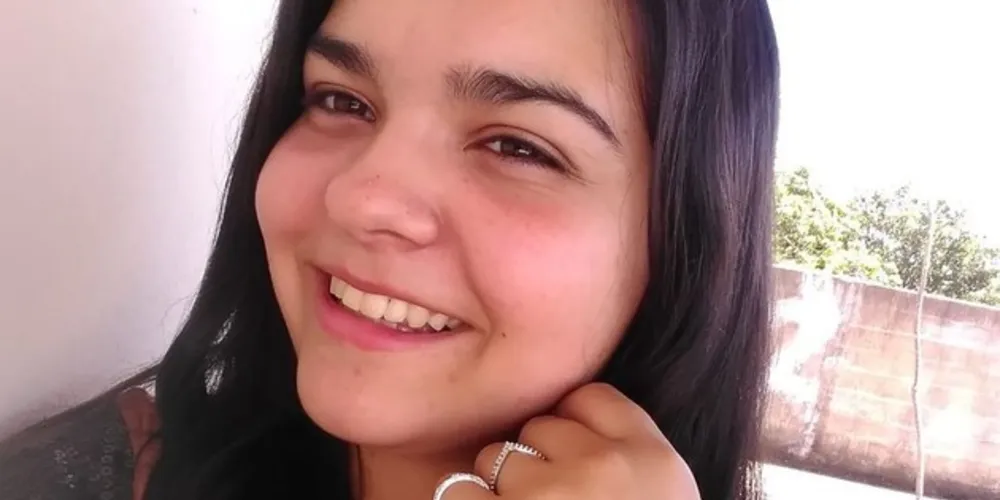 A última vez que foi vista ela vestia uma blusa laranja com mangas pretas e calça jeans