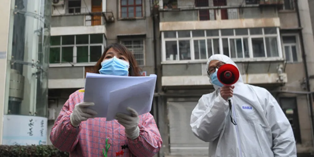 Os trabalhadores comunitários verificam as informações dos residentes no distrito de Jiangan, em Wuhan, província de Hubei, na China Central Wuhan, o epicentro do novo surto de coronavírus