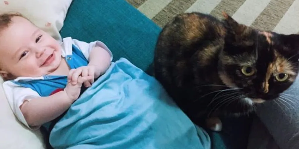 Mysha ao lado do bebê da família;