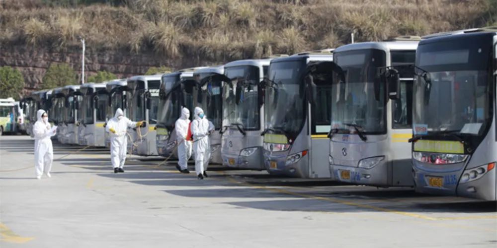 Os funcionários desinfetam os ônibus em Yichang, província de Hubei, na China Central