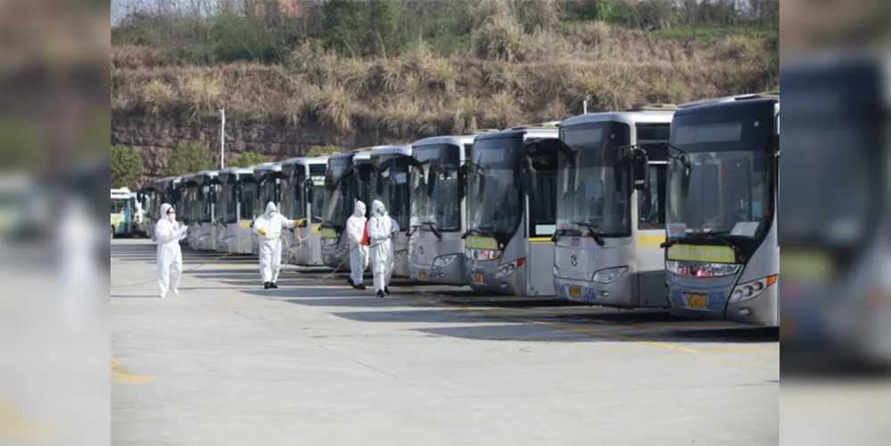 Os funcionários desinfetam os ônibus em Yichang, província de Hubei, na China Central