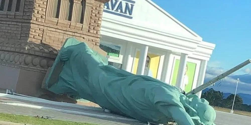 A estátua caiu sobre um poste de energia elétrica, que acabou atravessando a estrutura