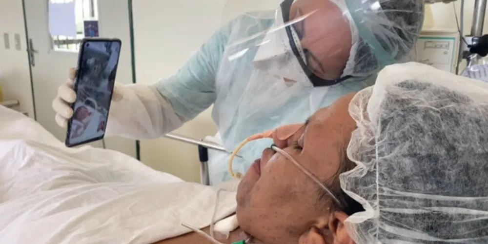 Enfermeira auxilia Brenda na realização da primeira chamada de vídeo com sua bebê recém-nascida,  enquanto ela ainda estava na UTI do Hospital Regional do Baixo Amazonas, em Santarém (PA).