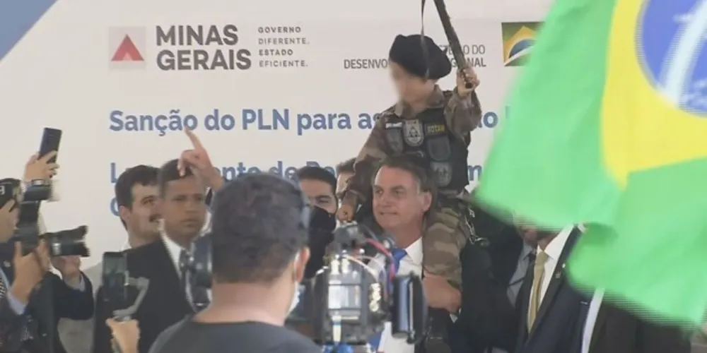 Bolsonaro posa para fotos com criança fardada e com arma de brinquedo na mão, em Belo Horizonte.