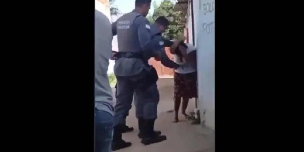O agente acerta socos, joelhadas e tapas na vítima, que apenas tenta se proteger