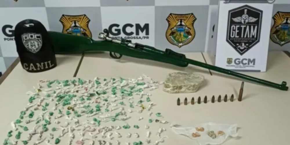 Policiais encontram um fuzil, munições e drogas no local.