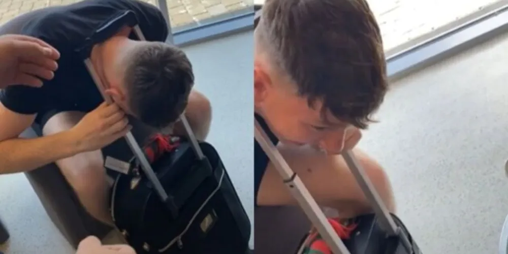 Nas imagens é possível ver o rapaz sentado em uma poltrona com a cabeça enroscada no puxador da mala