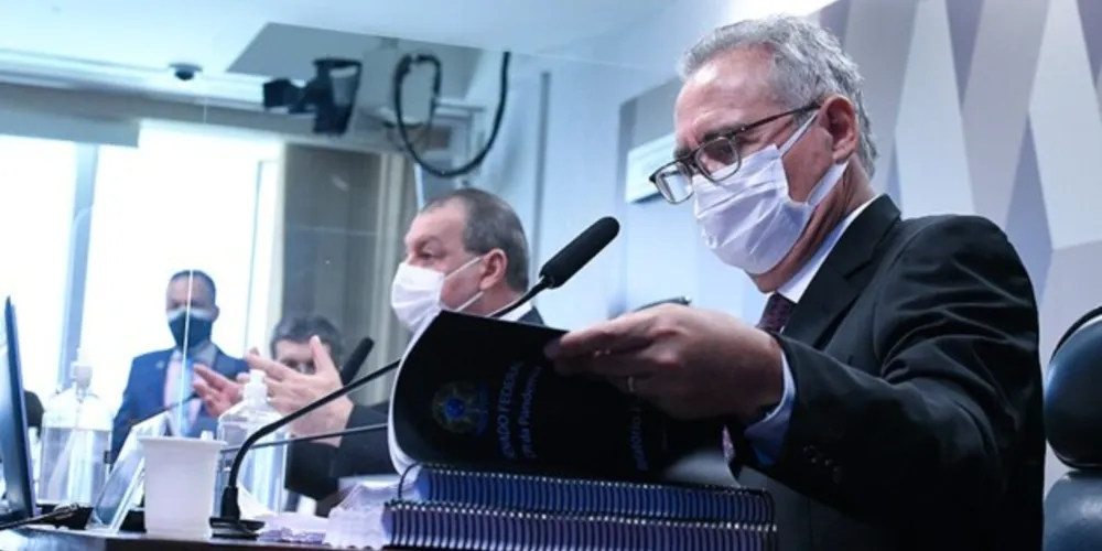 Renan lê o relatório ao lado do presidente Omar Aziz e do vice-presidente da CPI, Randolfe Rodrigues