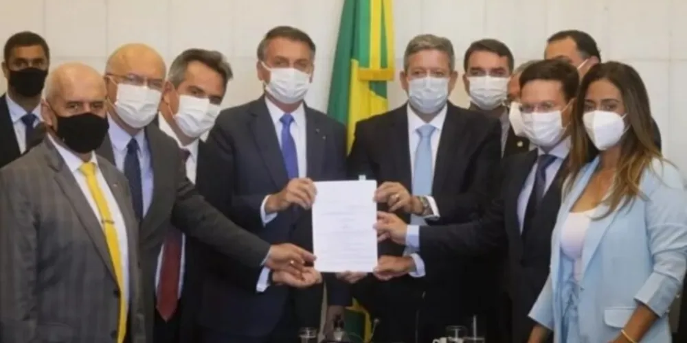 Presidente Jair Bolsonaro rodeado por parlamentares durante entrega da MP do Auxílio Brasil, em agostO