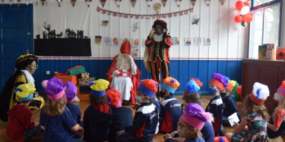 Sinterklaas visita escolas, com seus ajudantes, e distribui presentes.