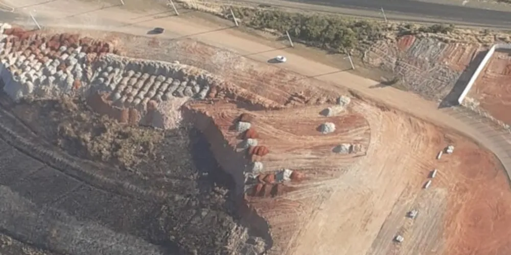 Parte do acesso ficou sem asfalto, após o avanço do muro que cerca a pista