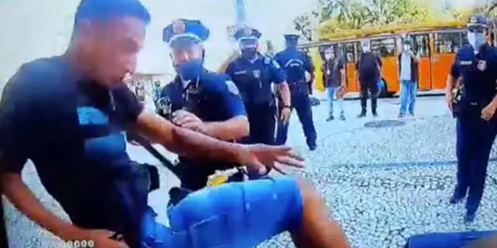 Um vídeo registrou o momento em que um dos homens está sendo algemado e outro chega para chutar um GM. 