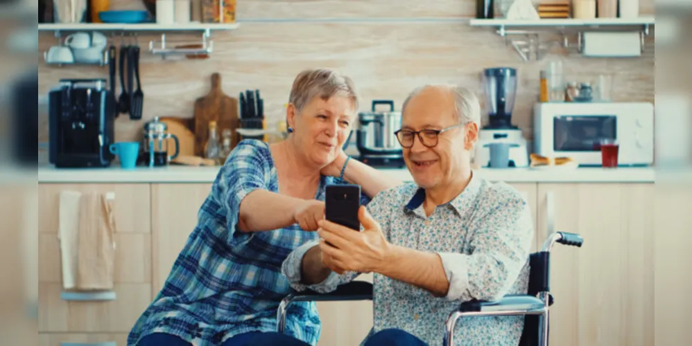 Idosos manuseando um smartphone moderno, em busca de entretenimento e passatempo.