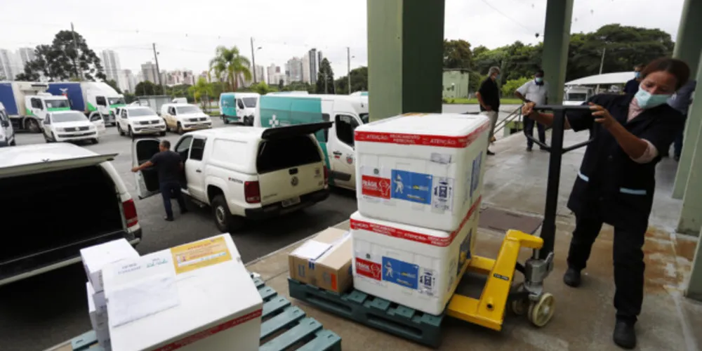 Funcionários do Cemepar carregando vacinas contra a Covid 19, para as 22 regionais de saúide do Paraná
