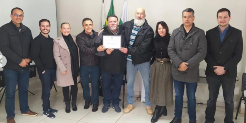 Ex-delegado Marcus Sebastião recebendo a homenagem do deputado federal Aliel Machado.