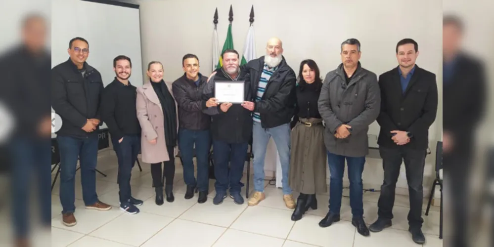 Ex-delegado Marcus Sebastião recebendo a homenagem do deputado federal Aliel Machado.