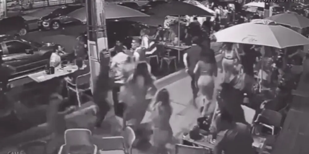 Ao perceberem a aproximação dos atletas, os clientes sentados começam a se levantar e correr