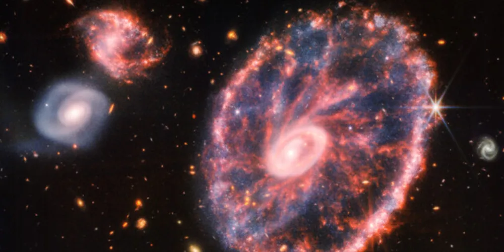 A imagem tem, ao fundo, várias outras galáxias – duas delas com maior destaque.