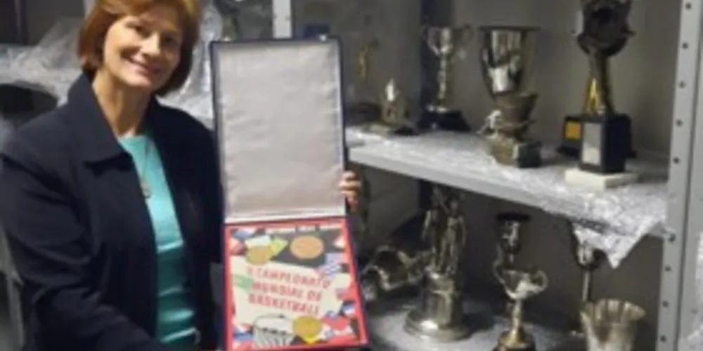 A presidente da AMBPG, Carmen Rachel Rosa Lima Cunha e Silva, a “Carminha,” destaca o acervo com a história do basquete