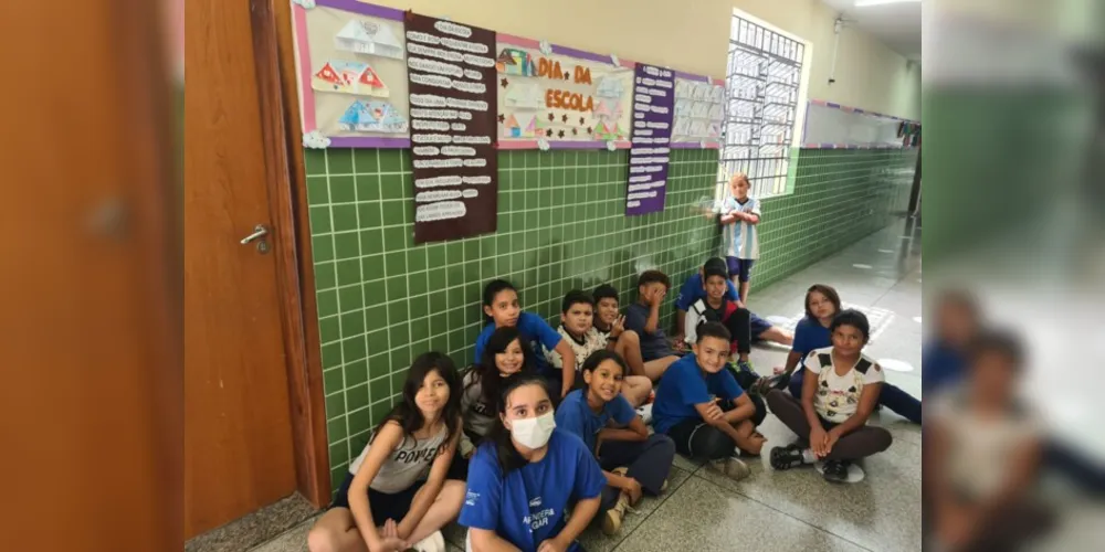 Os estudantes posando em frente aos cartazes por eles confeccionados