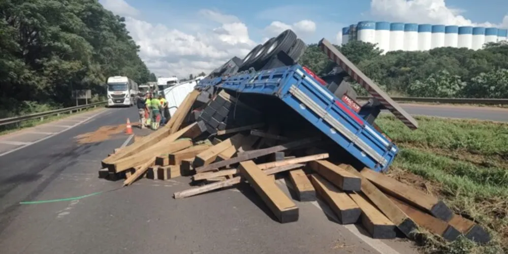 Carreta que transportava uma carga de madeira seguia pela estrada no sentido Curitiba, quando tombou e invadiu a pista contrária