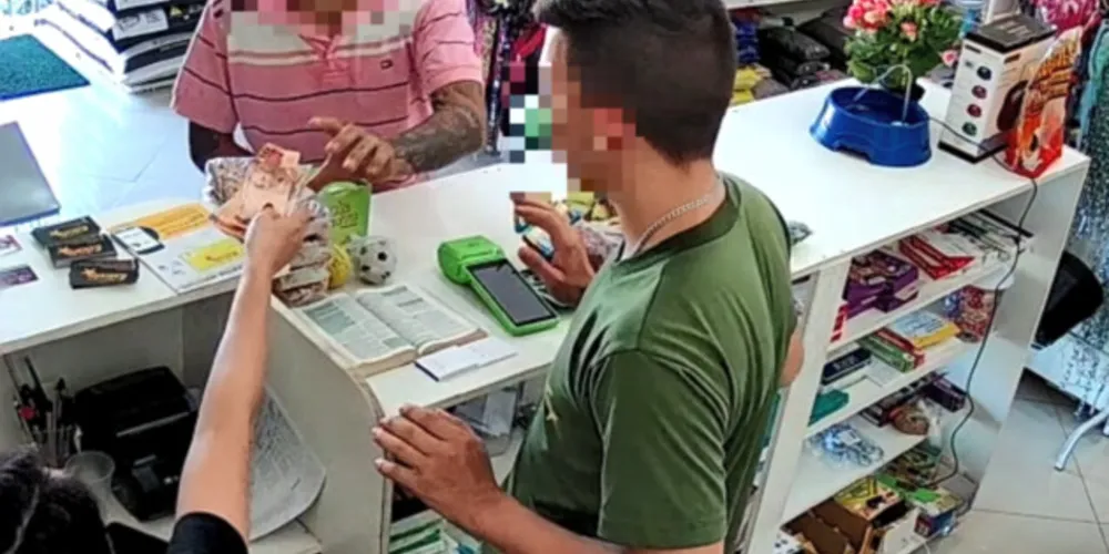 A ação começou quando o criminoso, de camiseta rosa gola polo e boné escuro, faz menção de estar armado