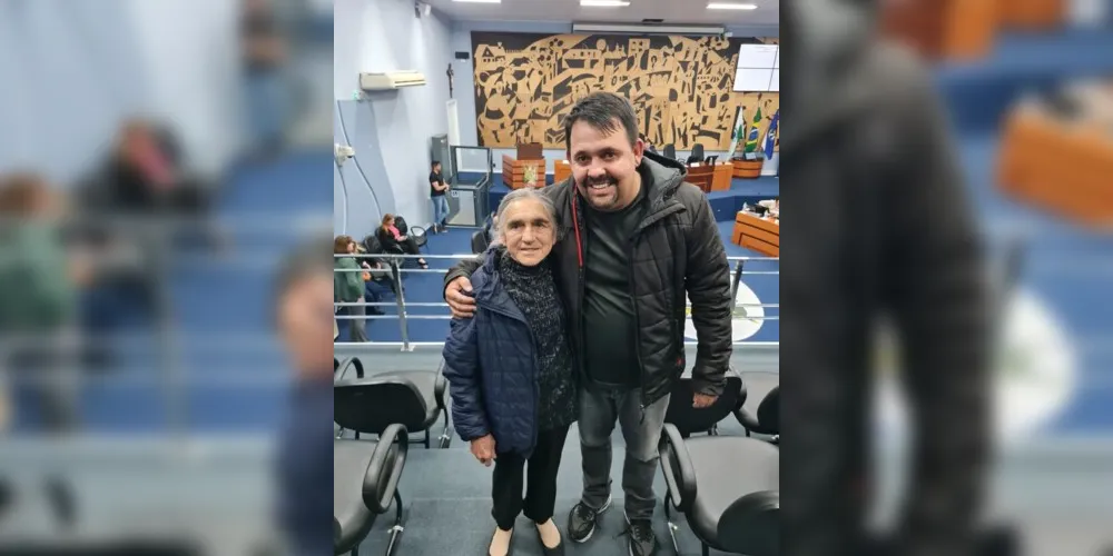 A homenageada, dona Sueli, ao lado do vereador autor do projeto de lei, acompanhando a sessão ordinária que resultou na aprovação do título