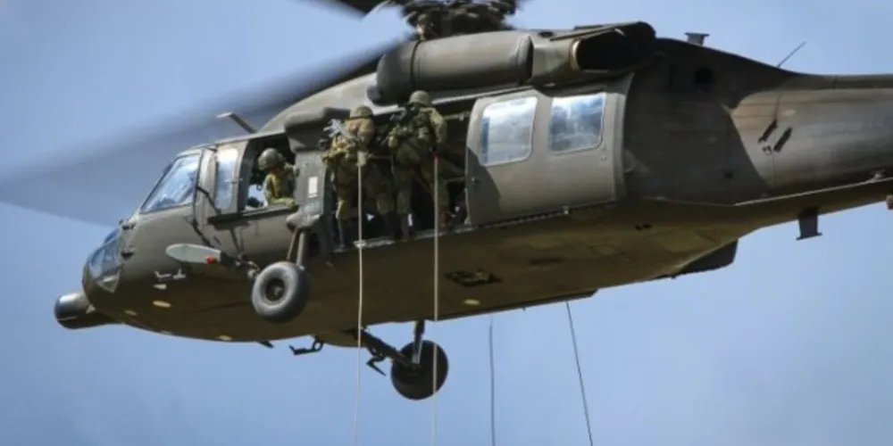 A equipe de resgate de um dos helicópteros utilizados na ação está descendo de rapel no local, na Serra do Mar, em busca dos ocupantes