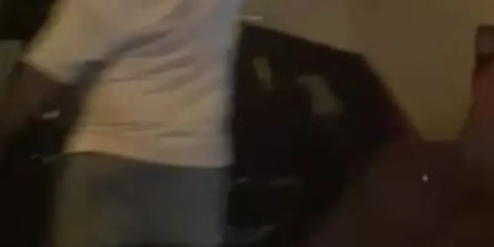 Homem com camiseta rasgada dispara tiros para o alto em briga de rua