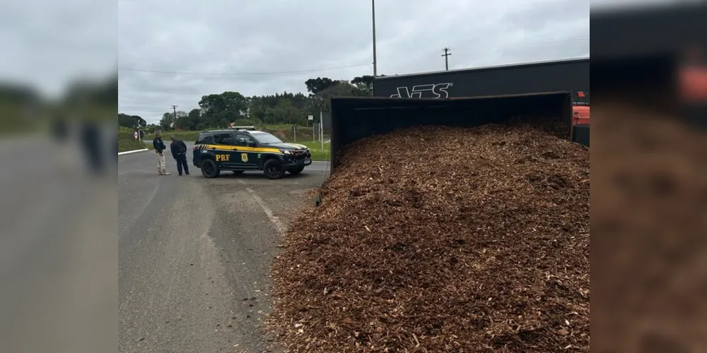 Um caminhão com placas de Prudentópolis, carregado com cavacos de madeira, tombou ao fazer a rotatória na BR-153