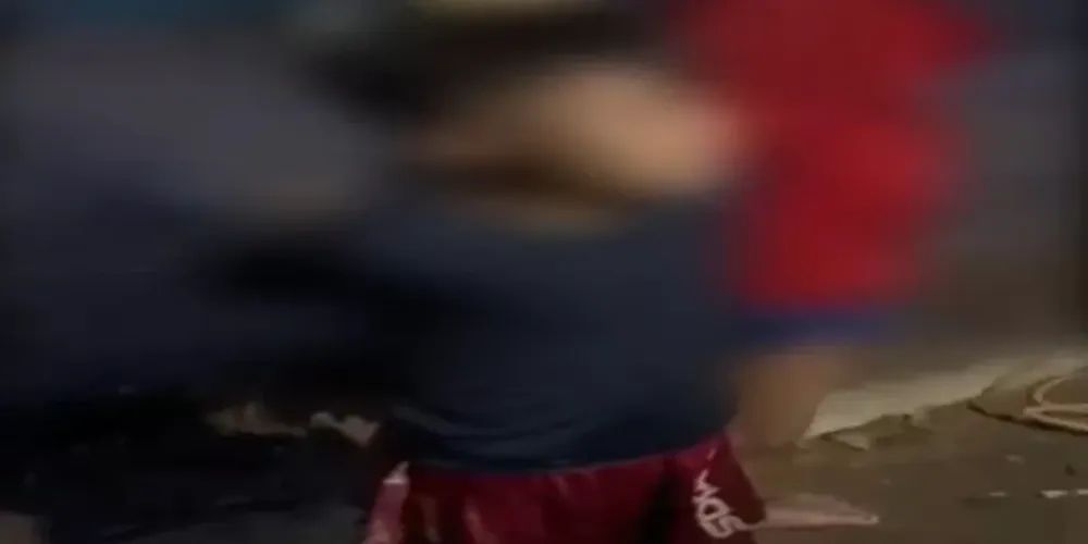 As imagens mostram duas crianças e um adolescente amarrados em troncos de árvore, e sendo ameaçados